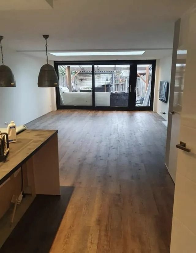 Groen mosbord voor aan de muur met een foto van een lachend kind op een grijze muur.