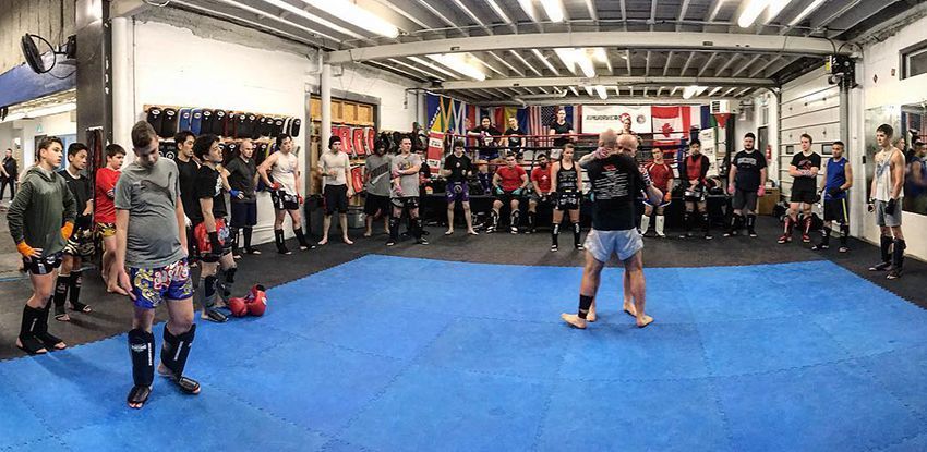 A group of people in a martial arts gym in Kitchener-Waterloo, ON, practicing kickboxing with an instructor