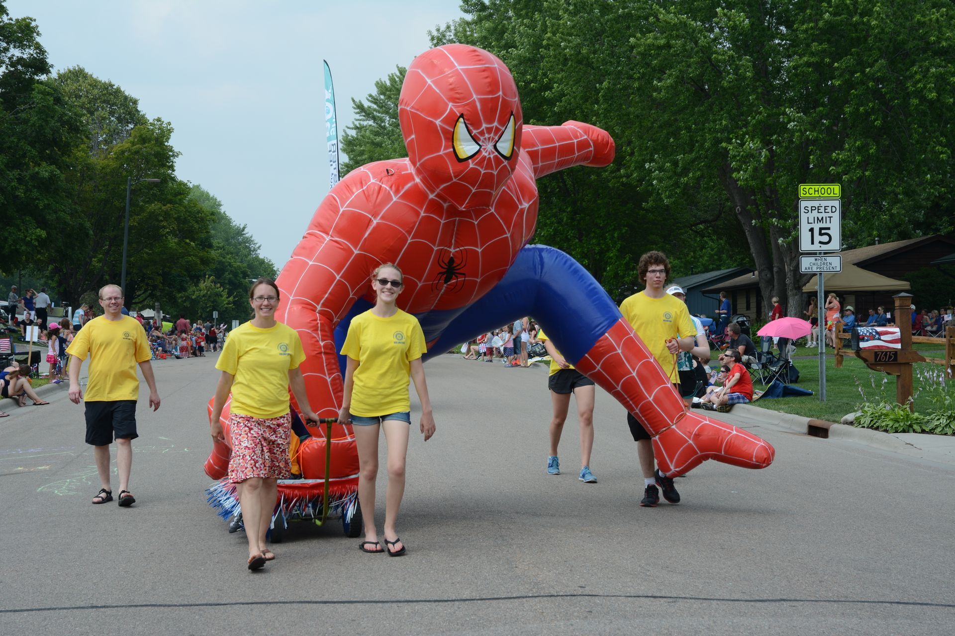 People parade with a large inflatable Spider-Man.