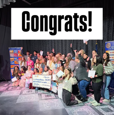 Group of people celebrating, holding awards, and a large check. 