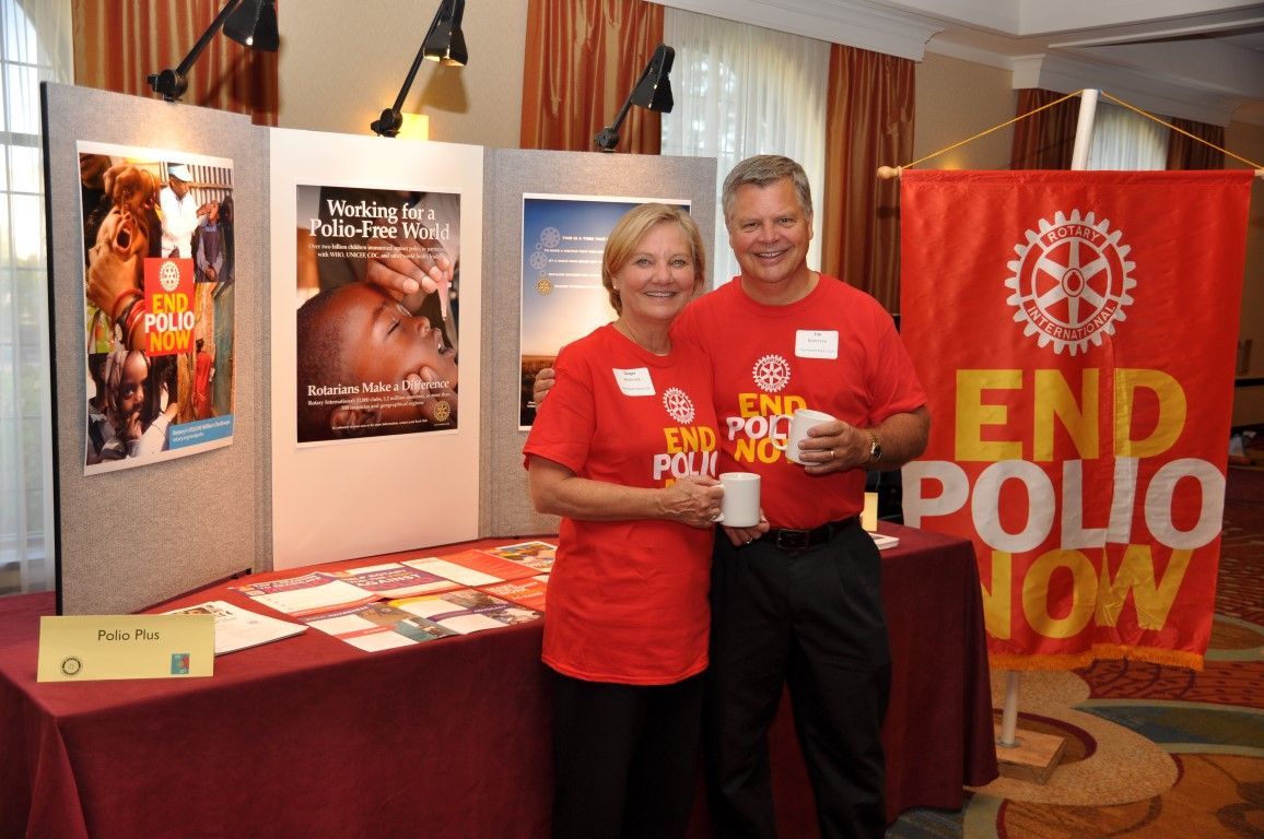 Two people stand near a booth with 