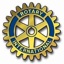 Woman with blonde hair, smiling, wearing a red tank top, against a dark background.