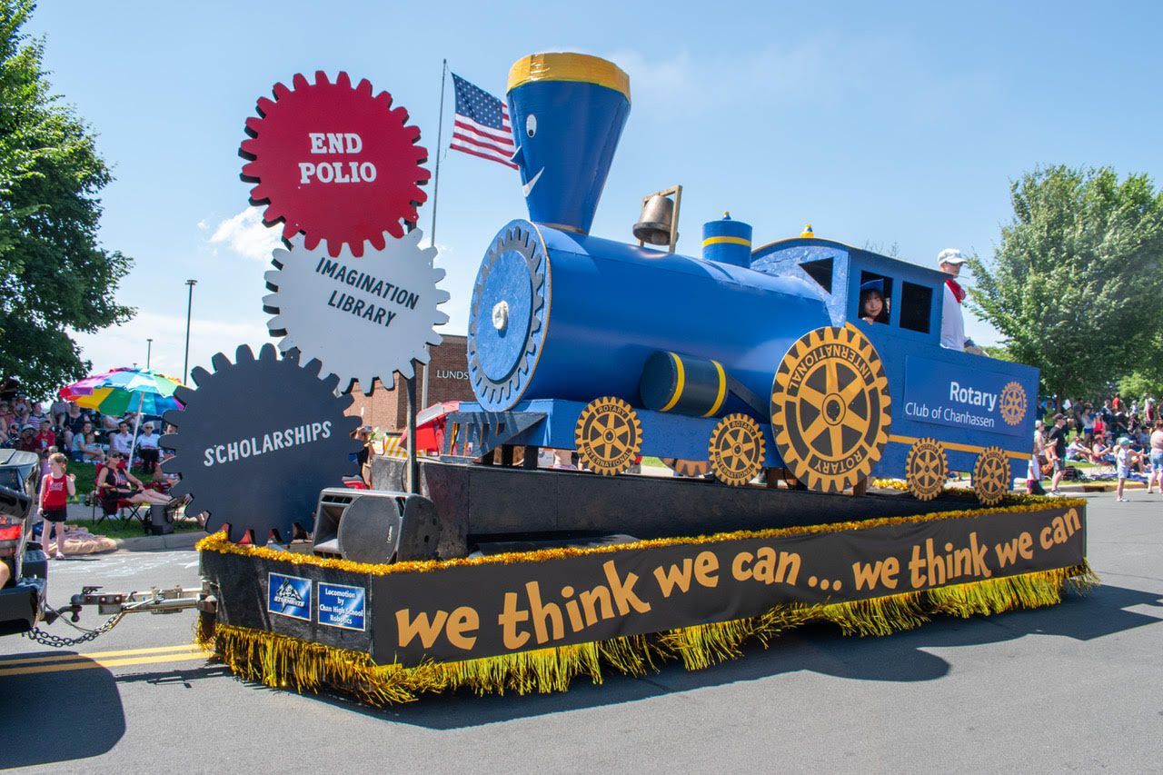 Blue train float in a parade, promoting 