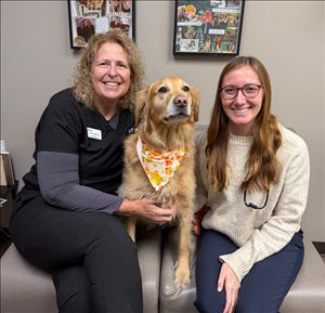 Rotary Club meeting; people seated at tables, speaker at podium showing a slide, American flag in background.