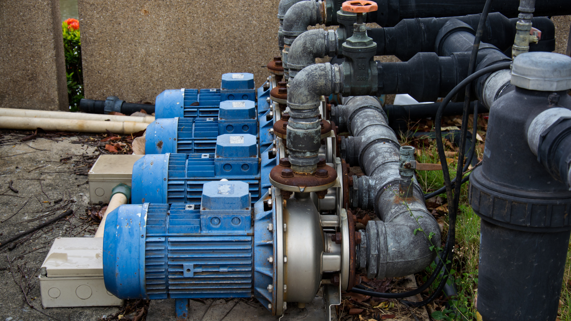 A group of water pumps are sitting next to each other on the ground.