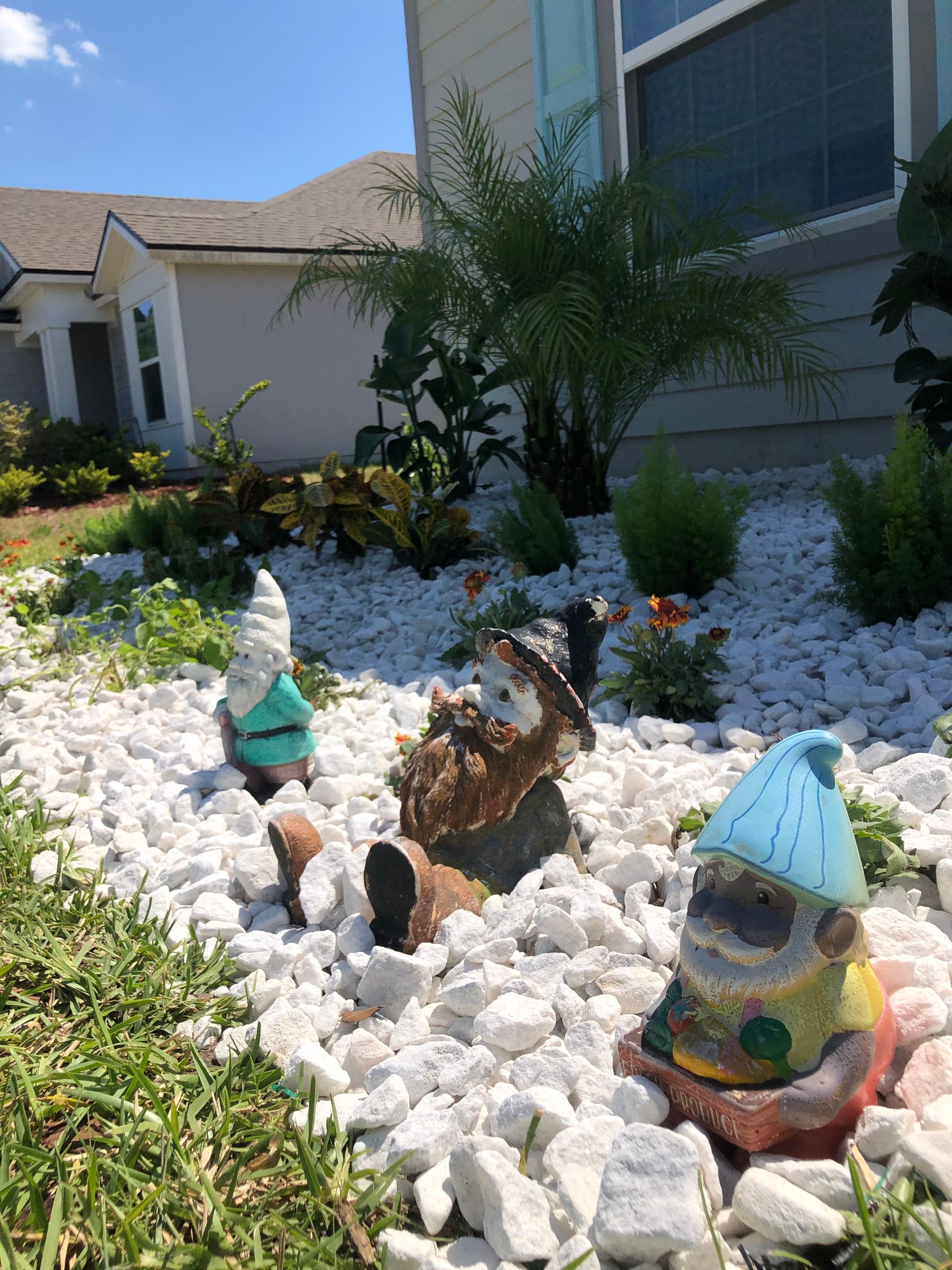 A group of gnomes sitting on top of a pile of rocks in a garden.
