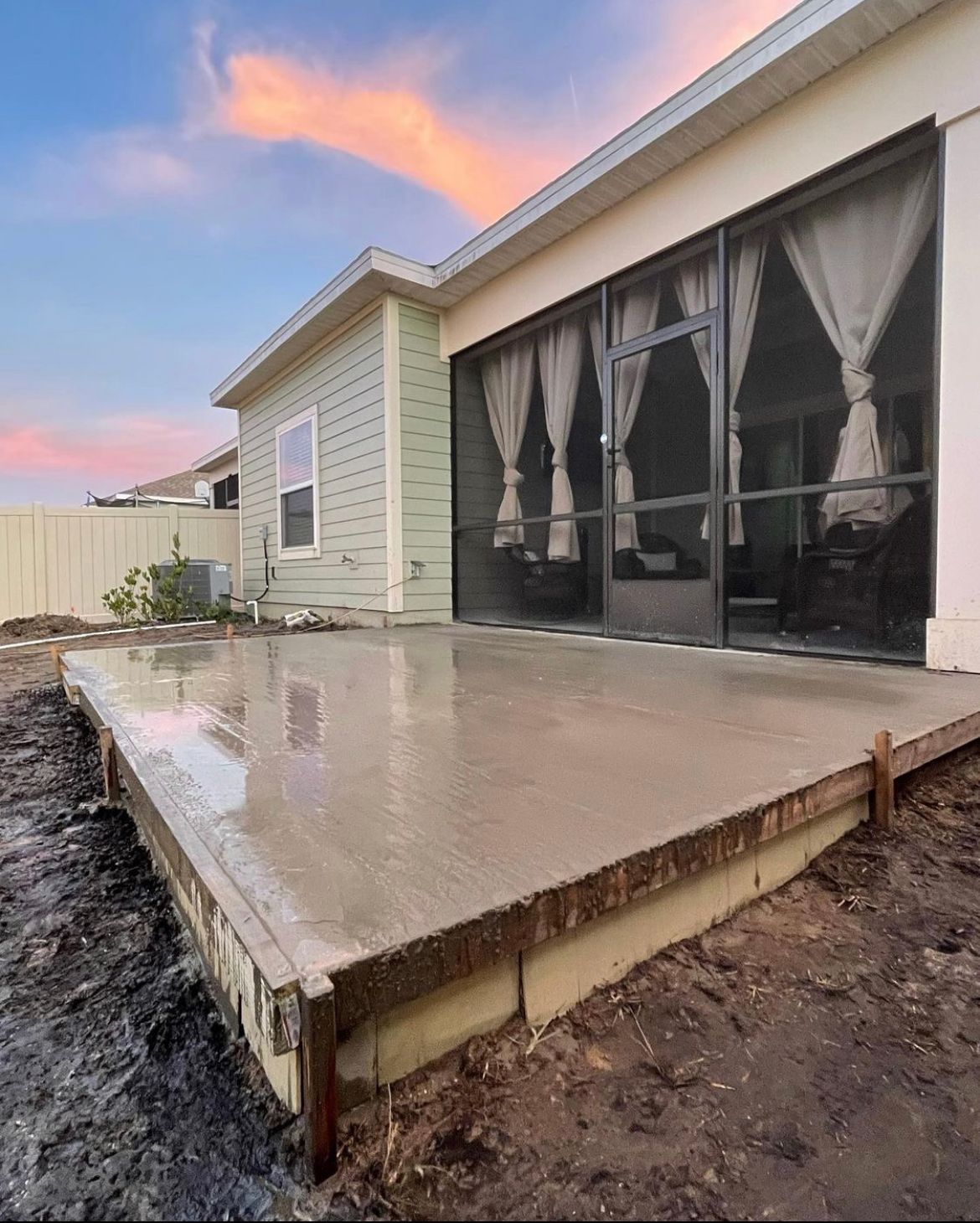 A concrete deck is being built in front of a house.