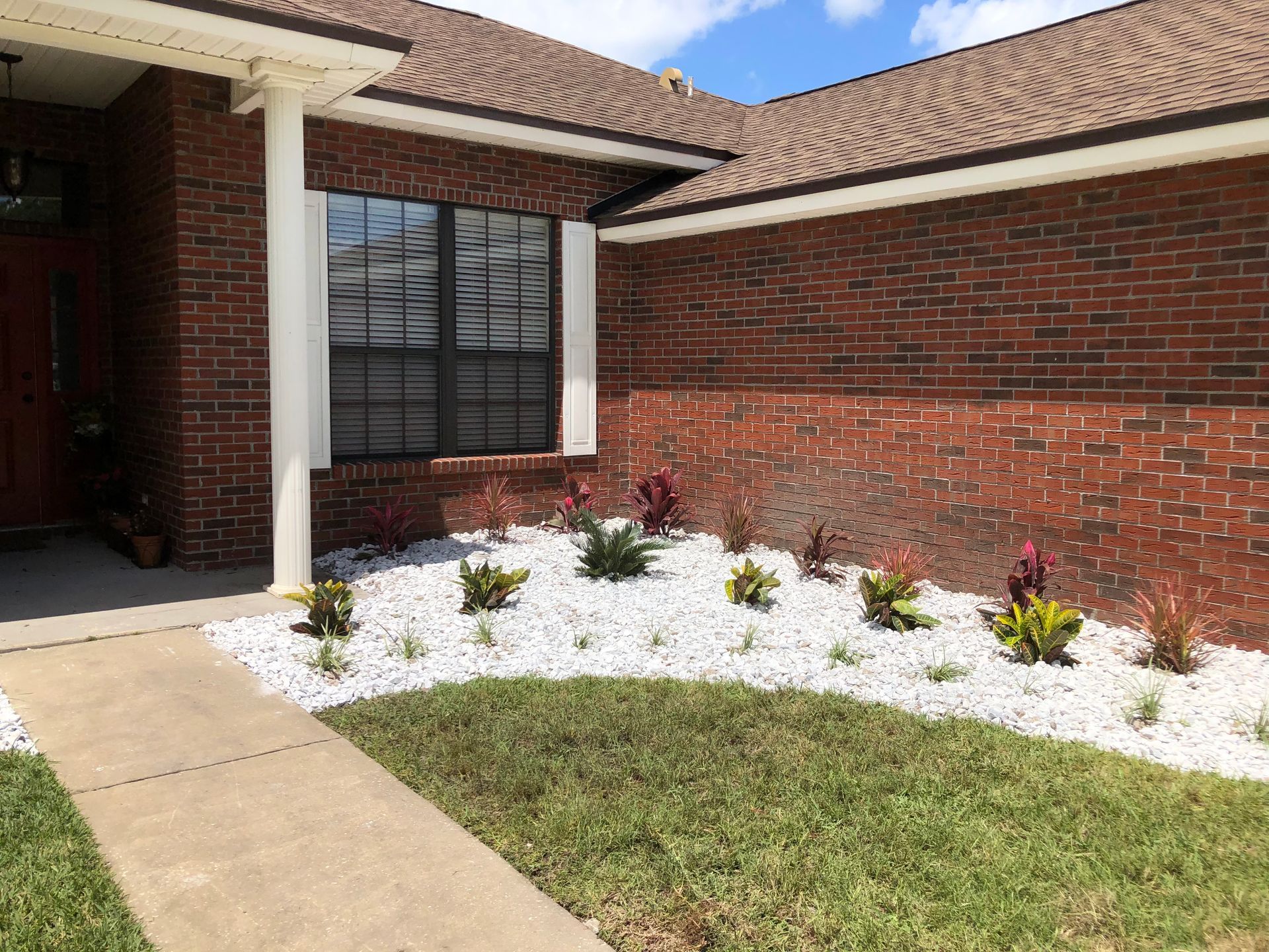 A brick house with a garden in front of it.