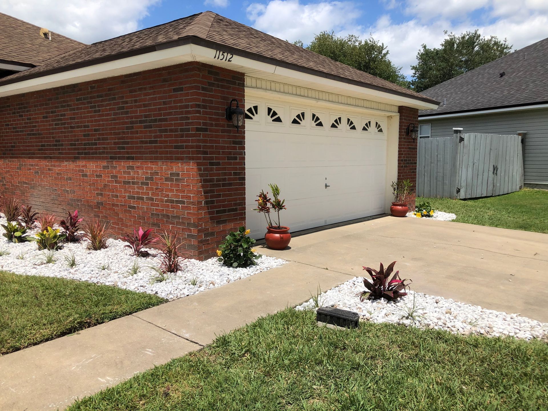 A brick house with a white garage door and a driveway.
