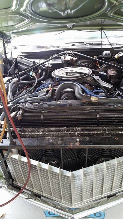 A close up of a car engine with the hood open.