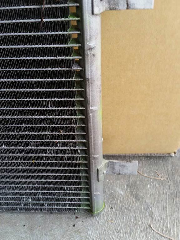 A radiator is sitting on the ground next to a cardboard box.
