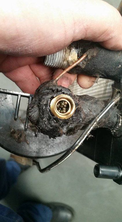 A person is holding a piece of metal with a hole in it.