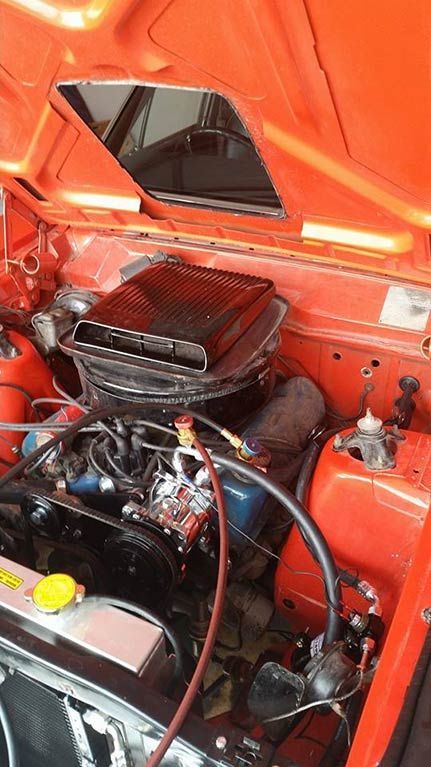 A close up of a car engine with the hood open.