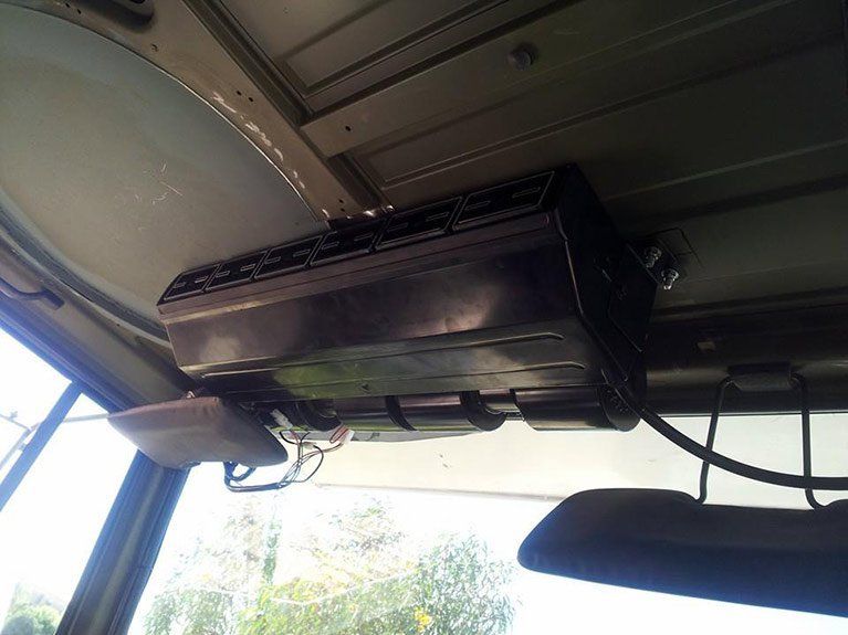 A black box is hanging from the ceiling of a vehicle