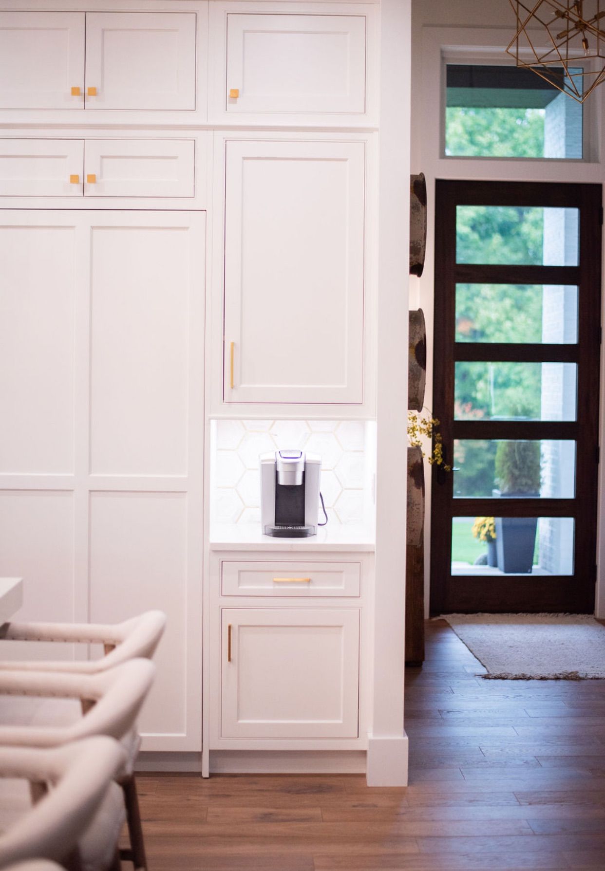 A kitchen with white cabinets and a coffee maker.