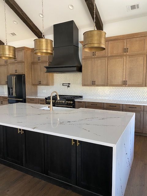A kitchen with black cabinets and white counter tops