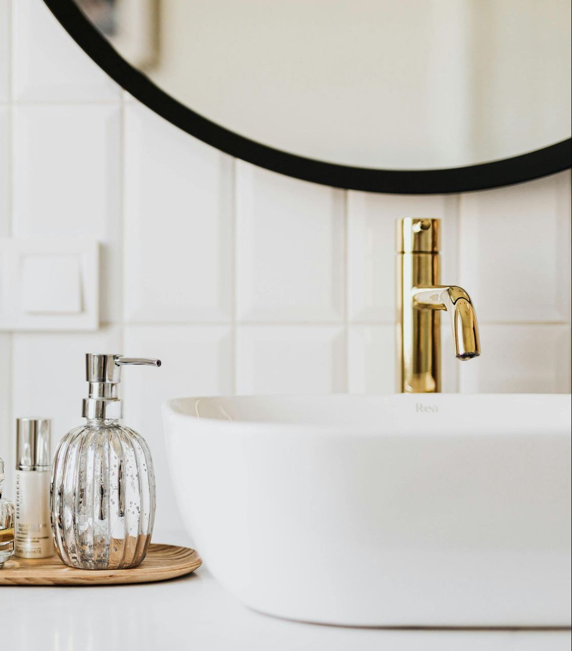 A bathroom with a sink , toilet , shower and mirror.