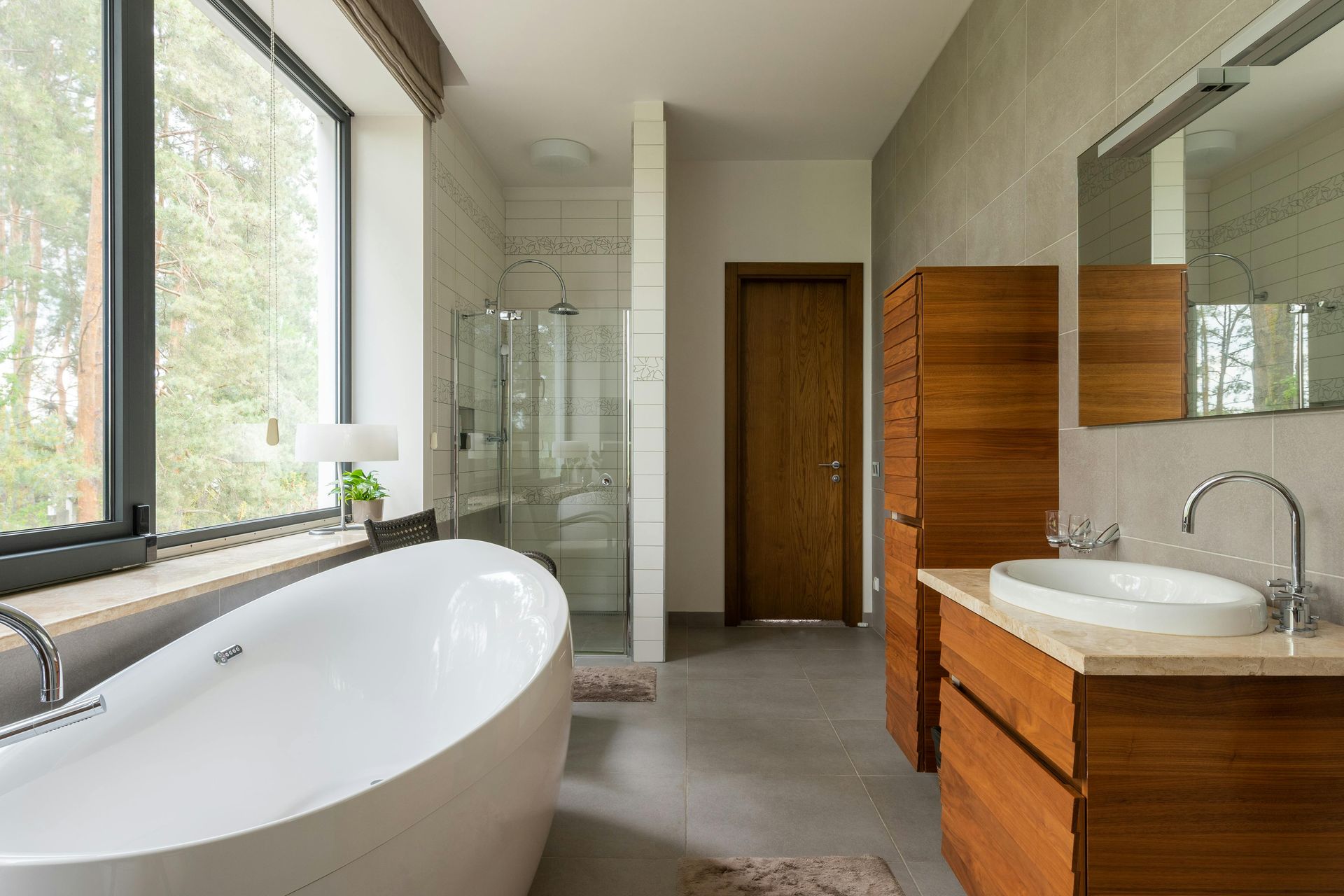 A bathroom with a sink , tub , mirror and walk in closet.