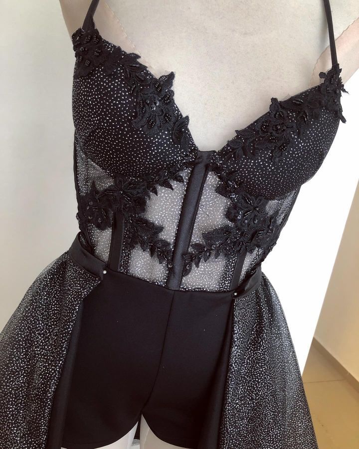 Una mujer lleva un vestido negro con un corsé en la parte superior.