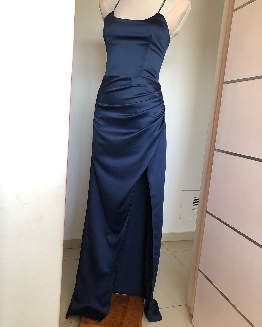 Un vestido azul está sobre un maniquí en una habitación.