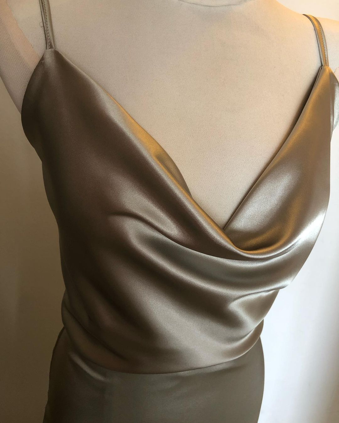 La parte trasera de un vestido de satén se muestra en un maniquí.
