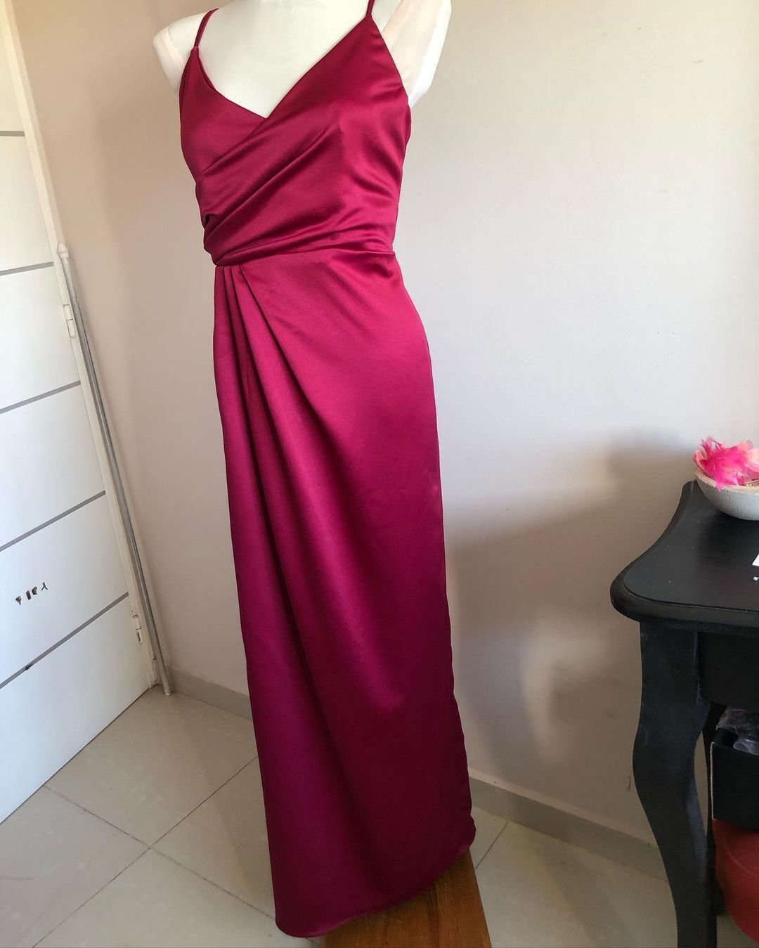 Un maniquí lleva un vestido largo rojo.