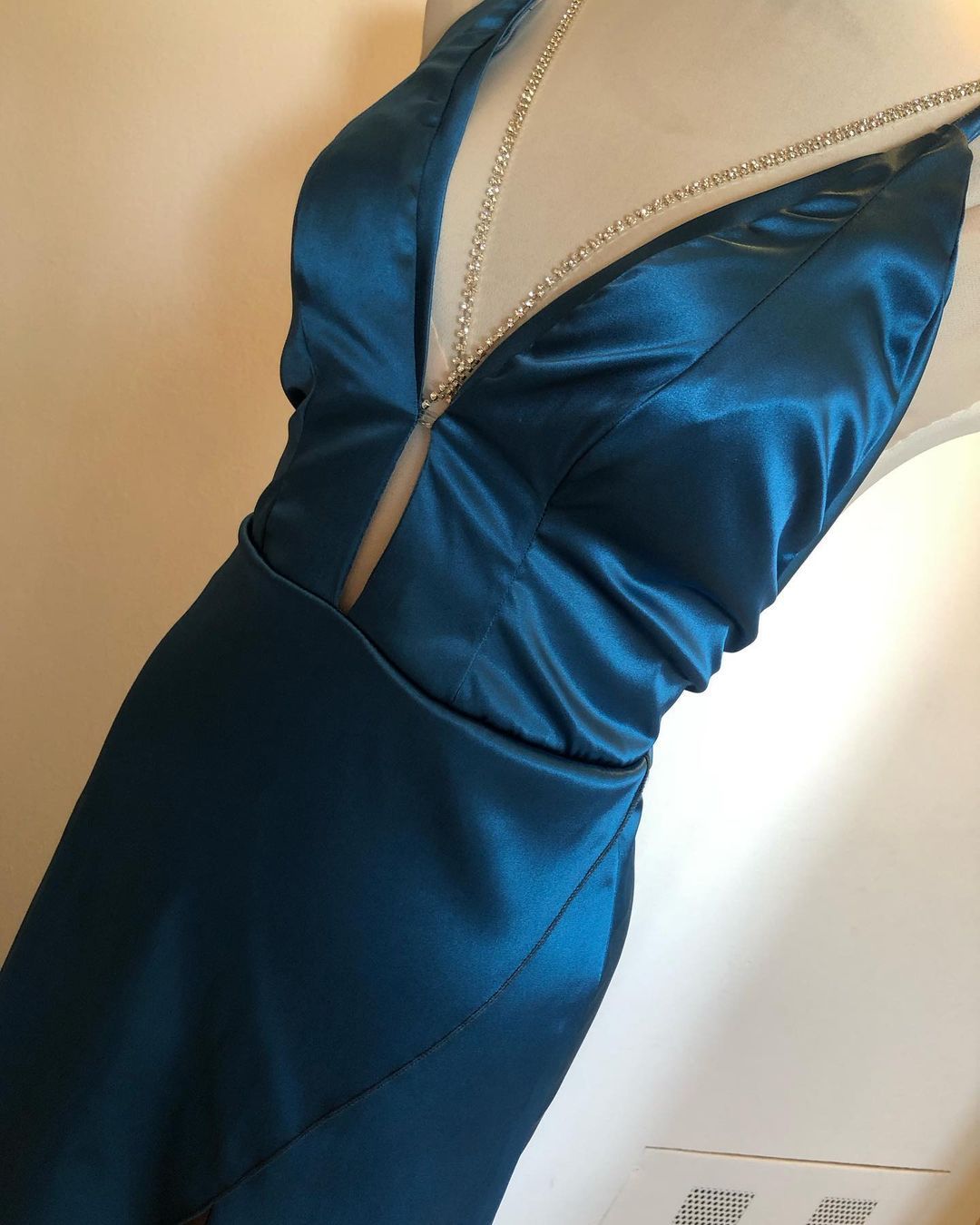 Un vestido azul con escote pronunciado está sobre un maniquí.