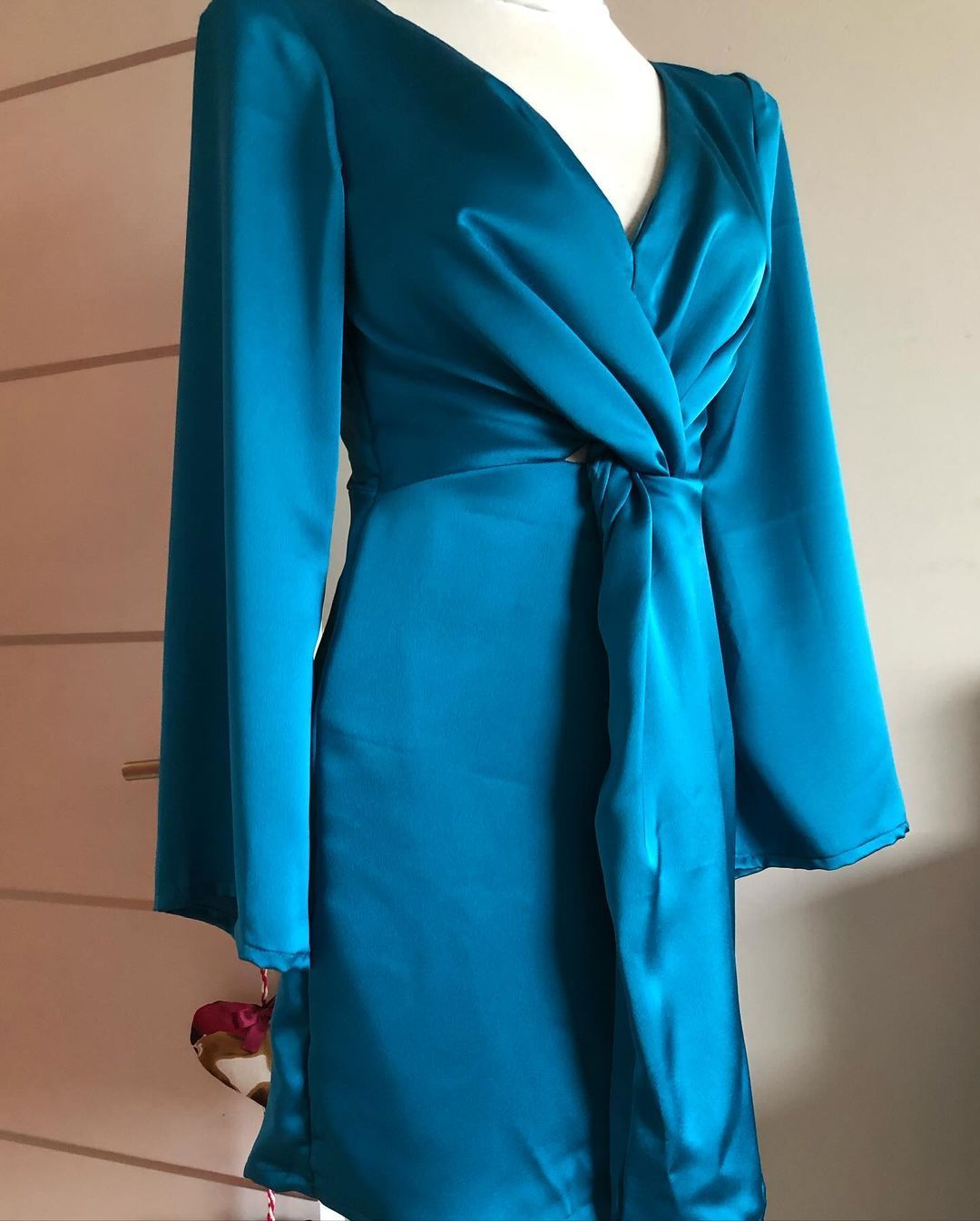 Un vestido azul con mangas largas está sobre un maniquí.