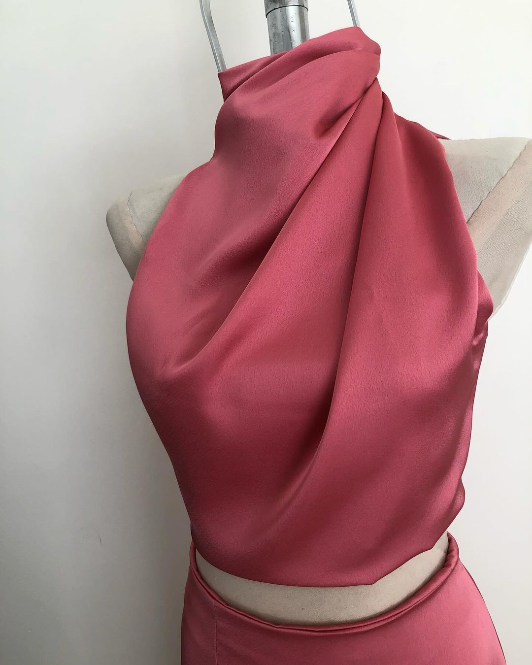 Un maniquí con un top y una falda de color rosa.
