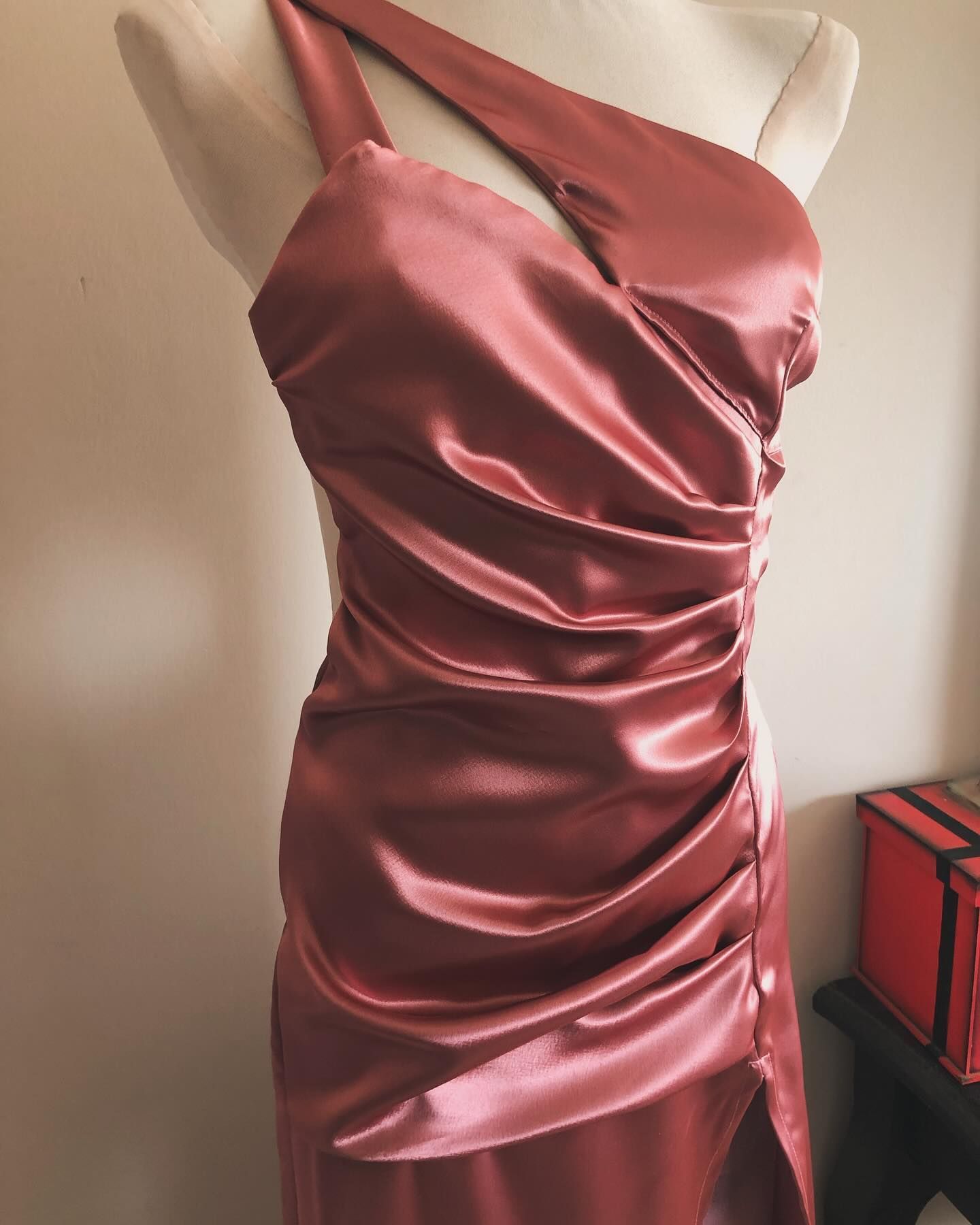 Un maniquí lleva un vestido de satén rojo.