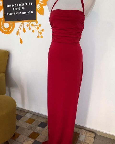 Un vestido rojo está sobre un maniquí en una habitación.