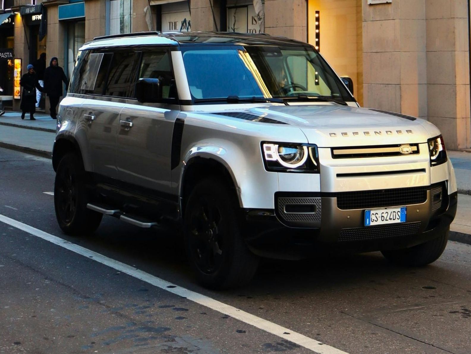 A silver land rover is parked on the side of the road