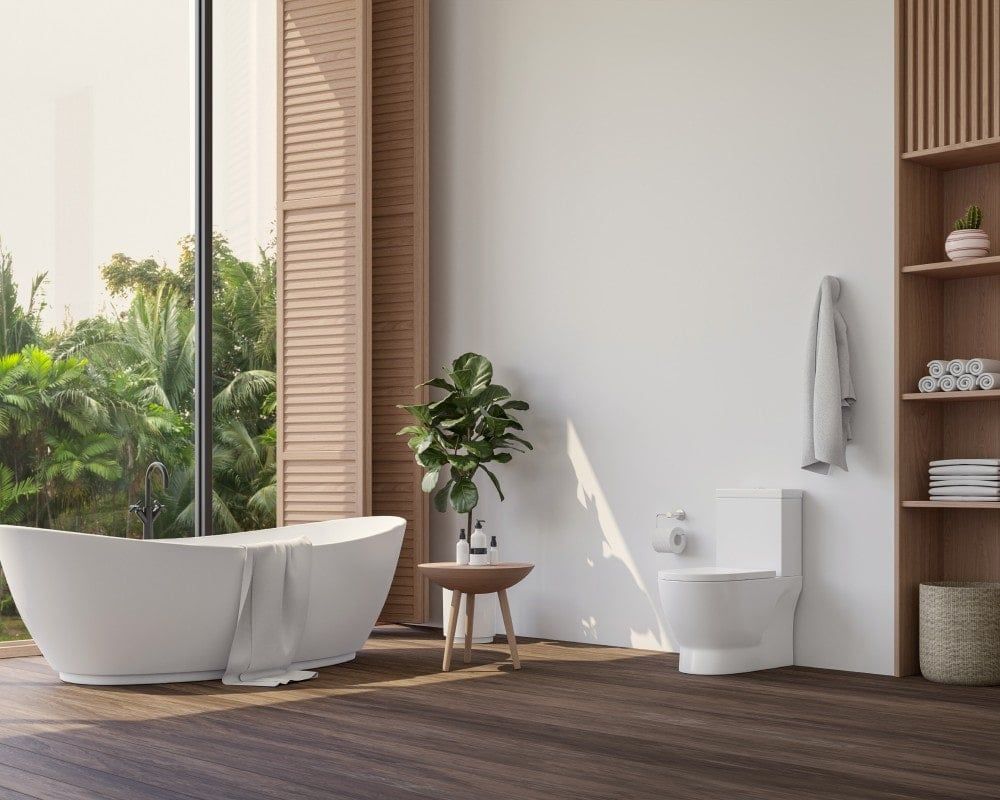 Modern bathroom with a white tub and toilet, wooden accents, and a large window overlooking greenery.