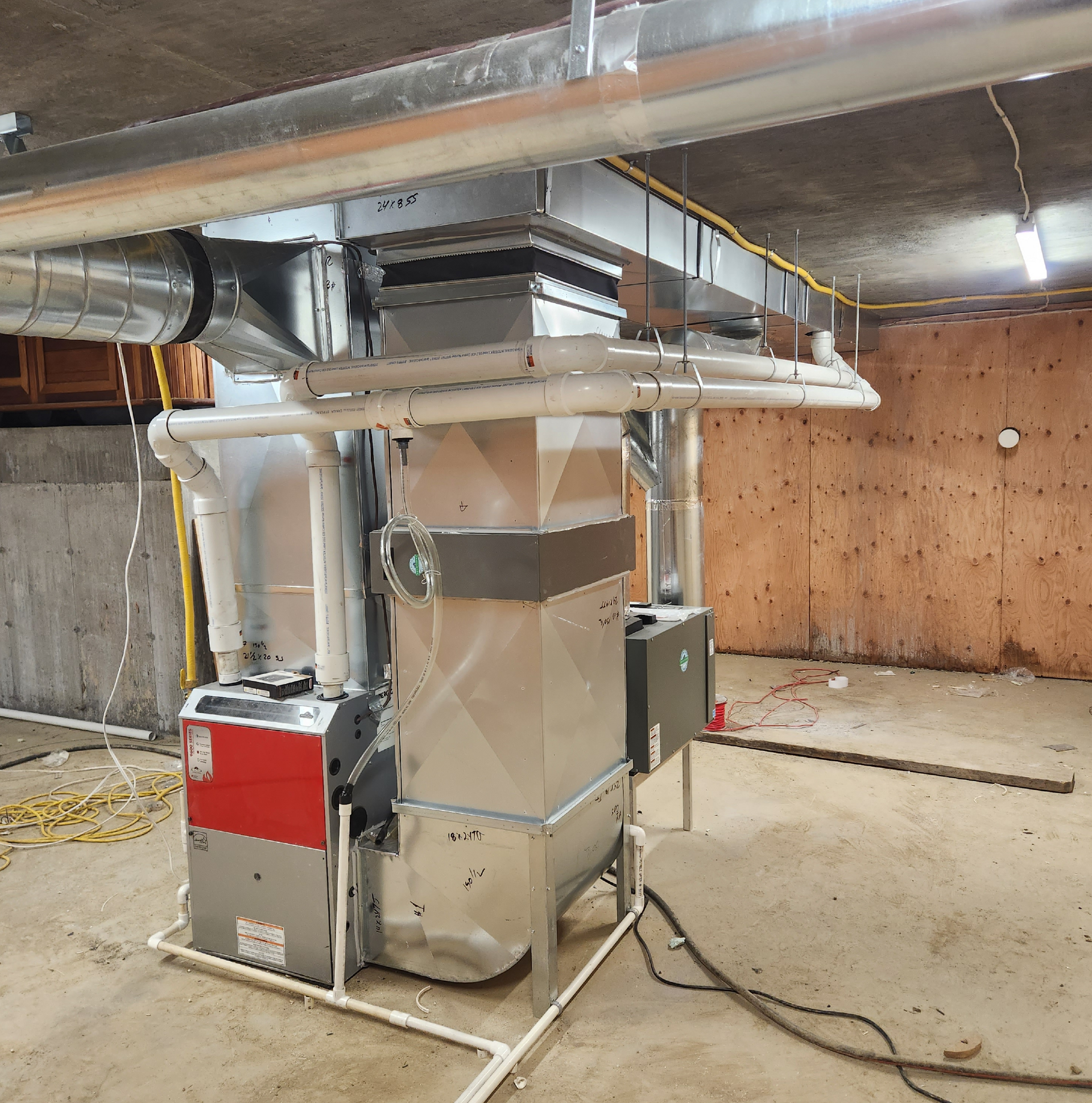 Une pièce avec un radiateur et des tuyaux suspendus au plafond