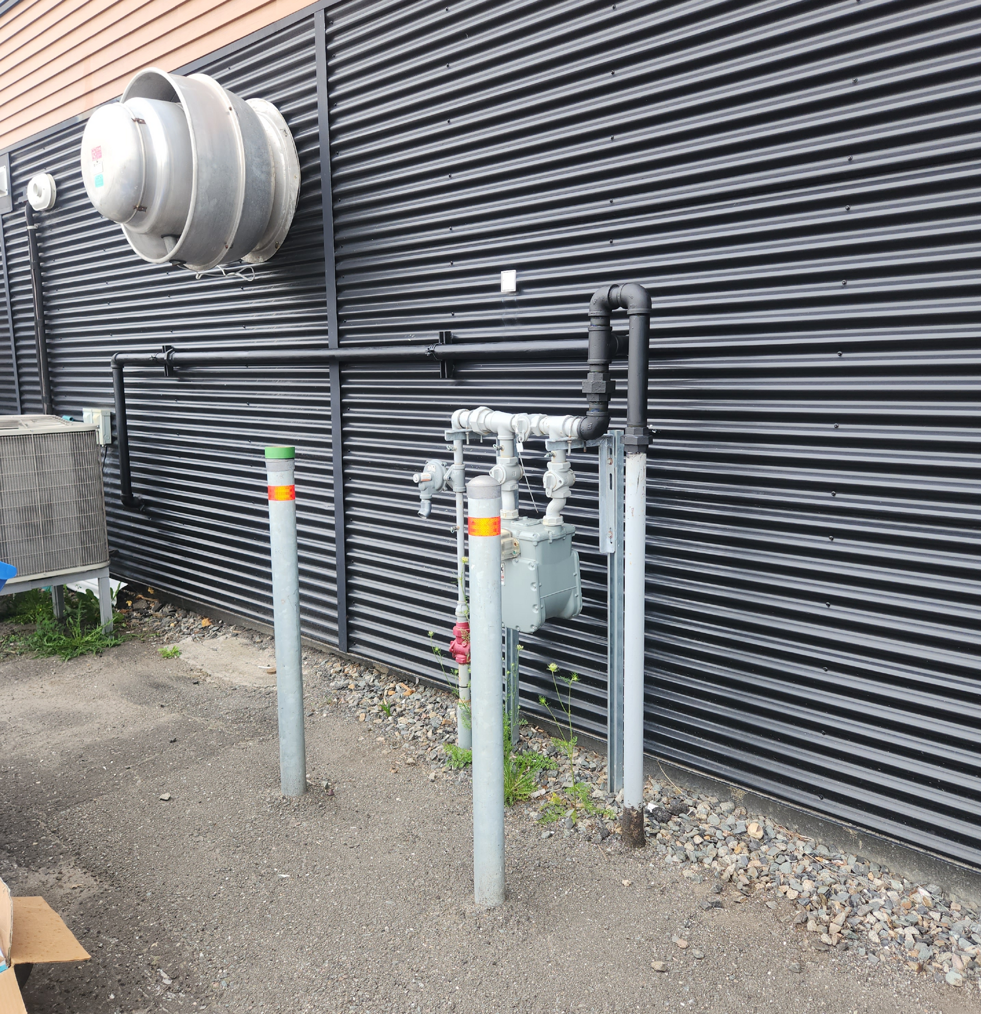 Un bâtiment avec beaucoup de tuyaux sur le côté.