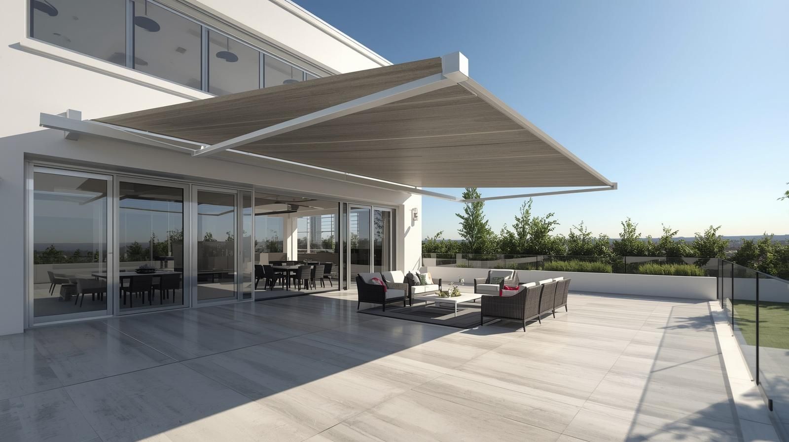 A beige retractable patio awning with a drop-down screen shade attached to the exterior wall of a brick house.