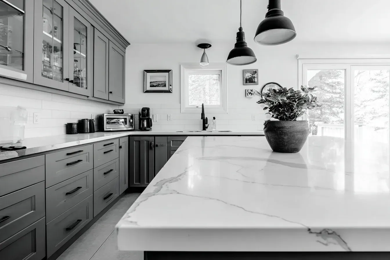 Designer kitchen renovation Burnaby British Columbia combining white marble islands, frameless cabinetry, and linear lighting. Professional builders use CAD-based design modeling for visual precision. The finished kitchen embodies minimalist sophistication.