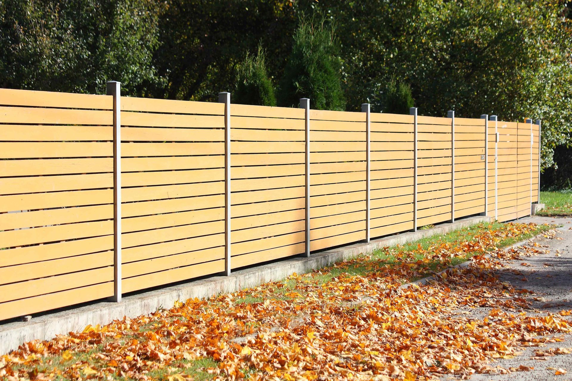 Modern horizontal wood privacy fence installed along a residential property line