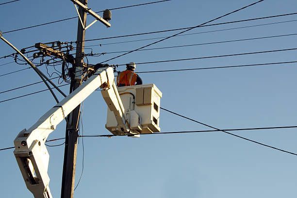 Technician using a cherry picker for maintenance work on a high-voltage cabling system