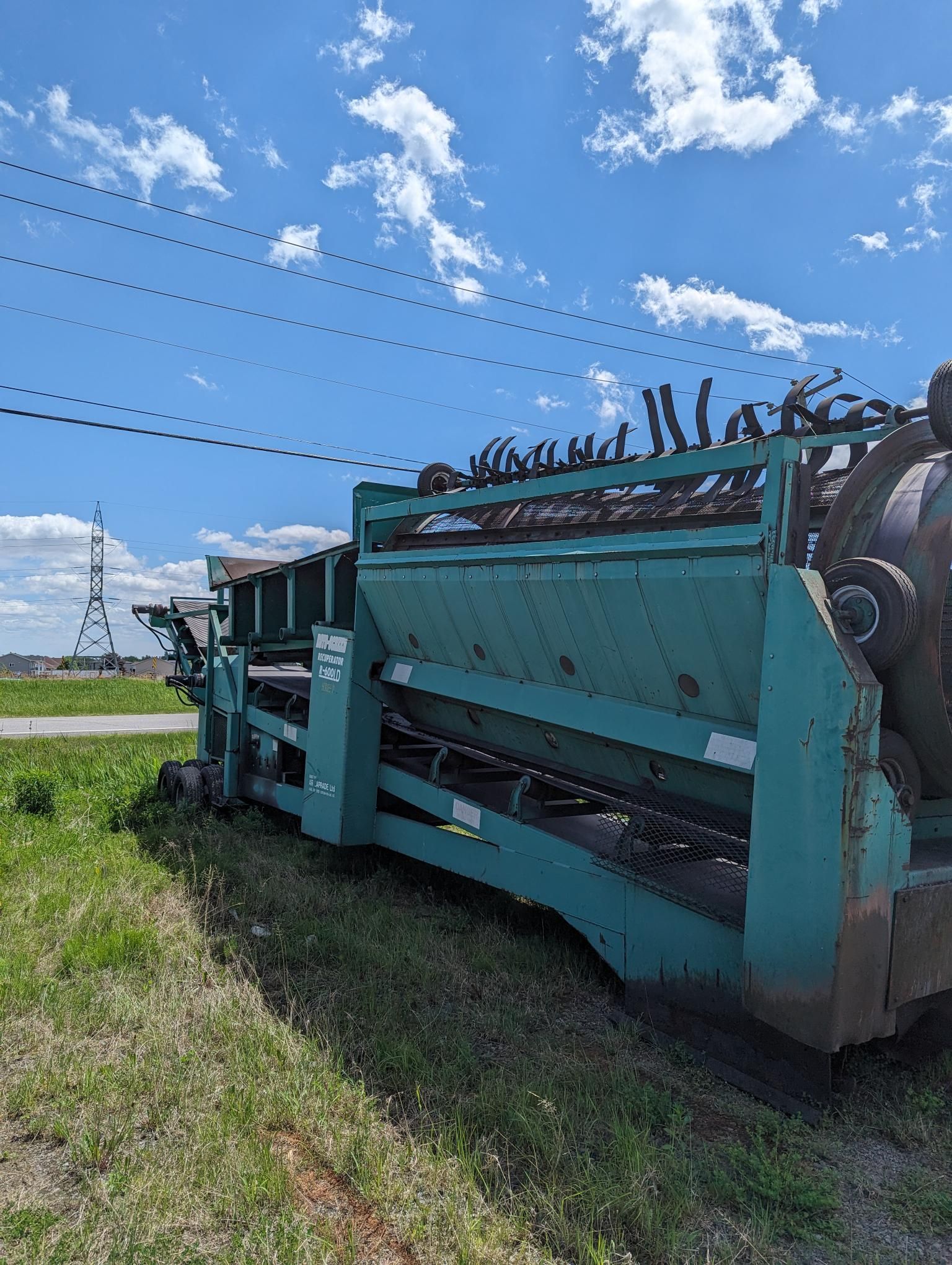 Une machine verte est assise au milieu d'un champ herbeux.