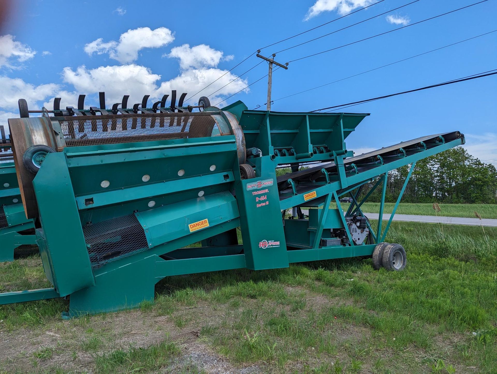 Une machine verte est assise au milieu d'un champ herbeux.