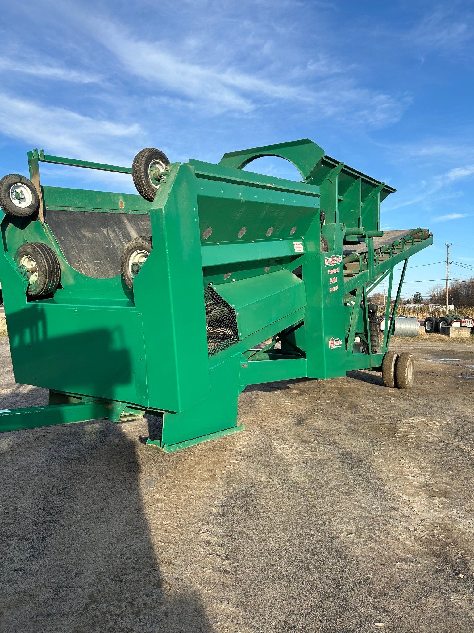 Une machine verte est assise au milieu d'un champ herbeux.