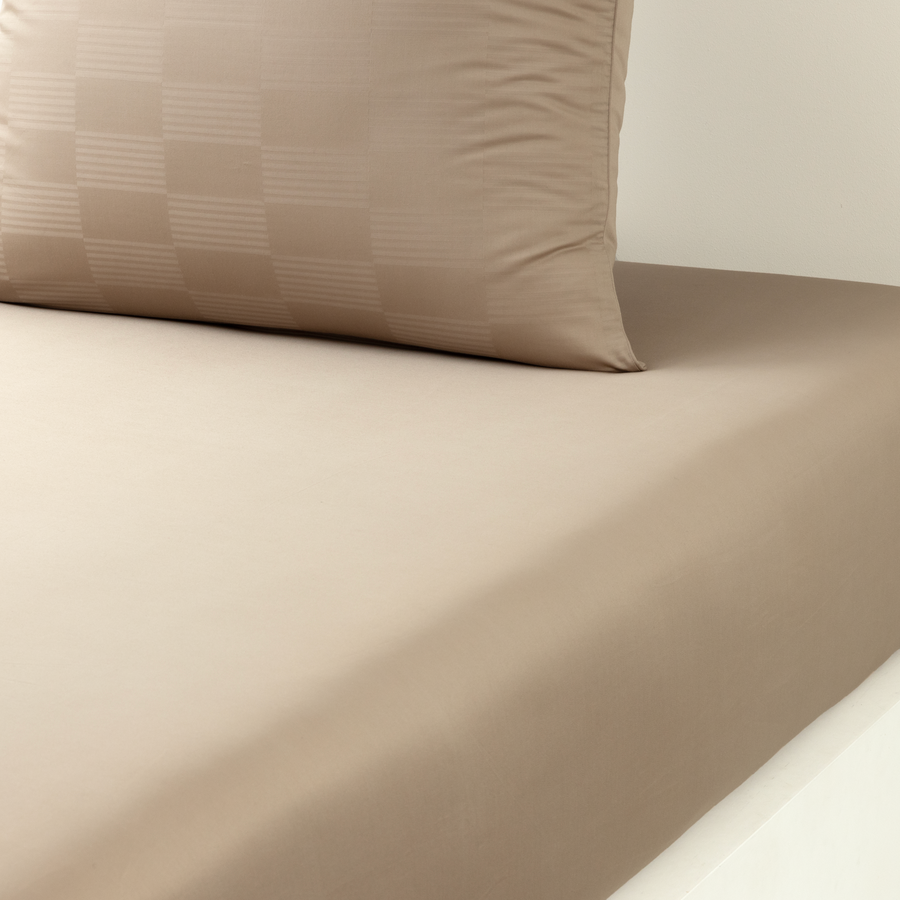 Un lit avec un couvre-lit et deux oreillers dessus.