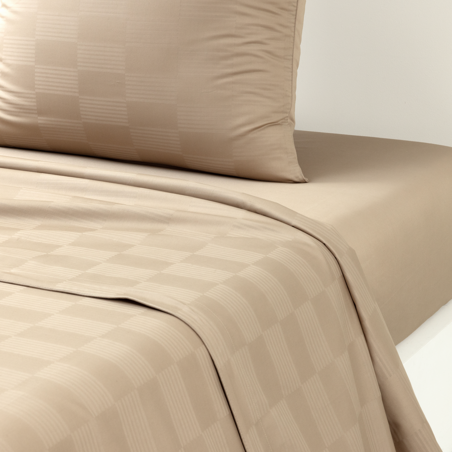 Un lit avec une couette à carreaux et des oreillers