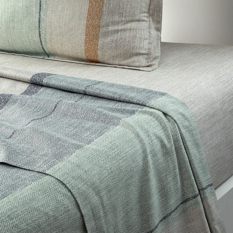 Un lit avec une couverture et des oreillers dessus.