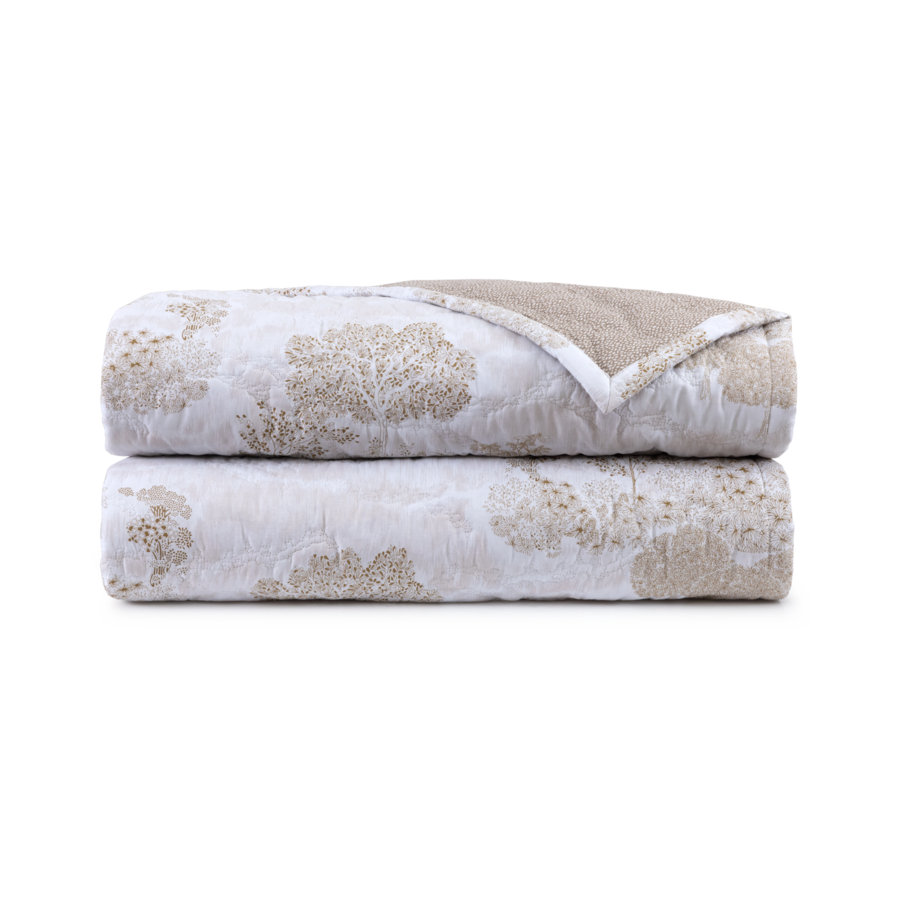 Deux couvertures pliées, à motifs d'arbres beiges sur fond blanc, empilées l'une sur l'autre.