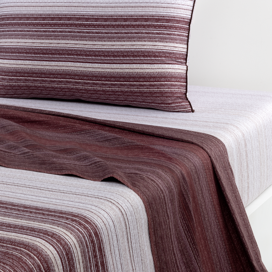 Ensemble de literie comprenant une couette à rayures blanches et bordeaux et une taie d'oreiller assortie.