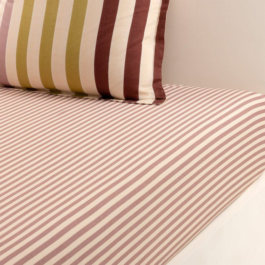 Un lit avec des draps et des oreillers rayés