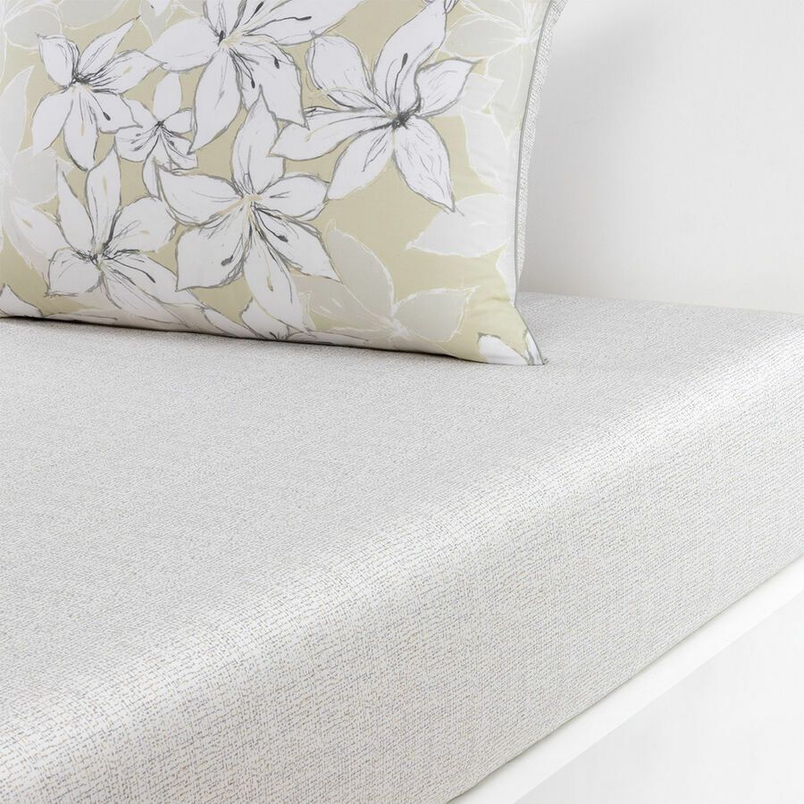 Un oreiller avec des fleurs dessus est posé sur un lit