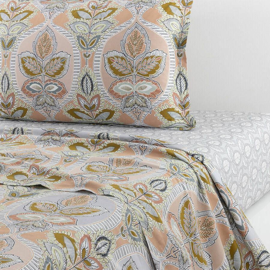 Ensemble de literie à motifs floraux dans les tons pêche, or et gris.